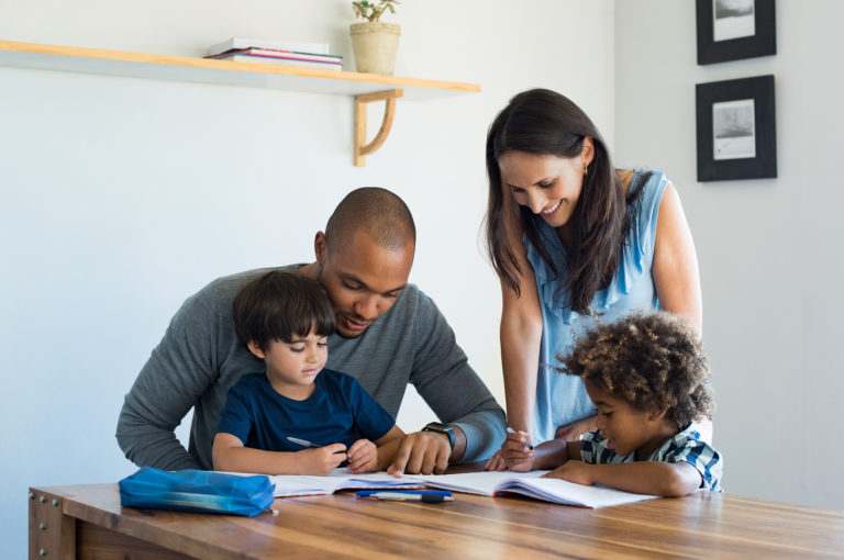 Multiethnic parents helping children with their homework at home