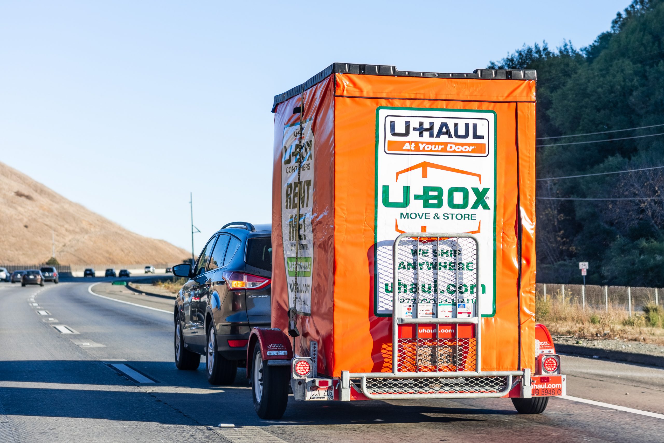 Semi truck towing an U-Haul cargo box trailer