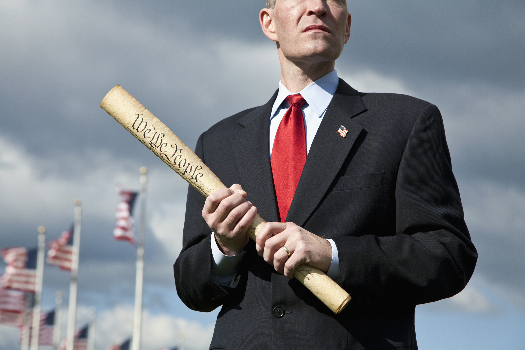 A politician holding a rolled up US Constitution