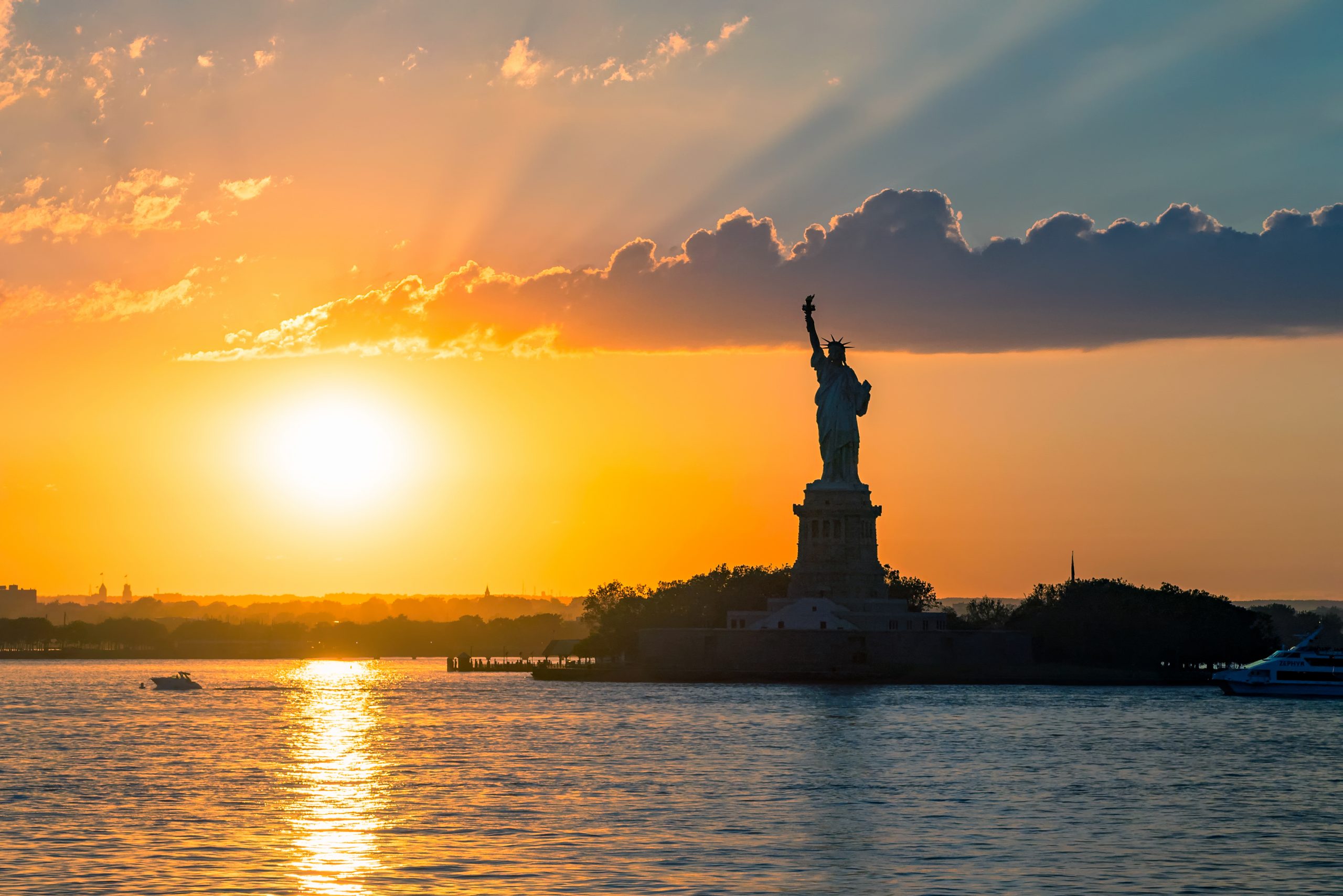 Statue of Liberty sunset. NYC harbor, Manhattan.