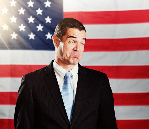 Man in front of American flag pulls a face