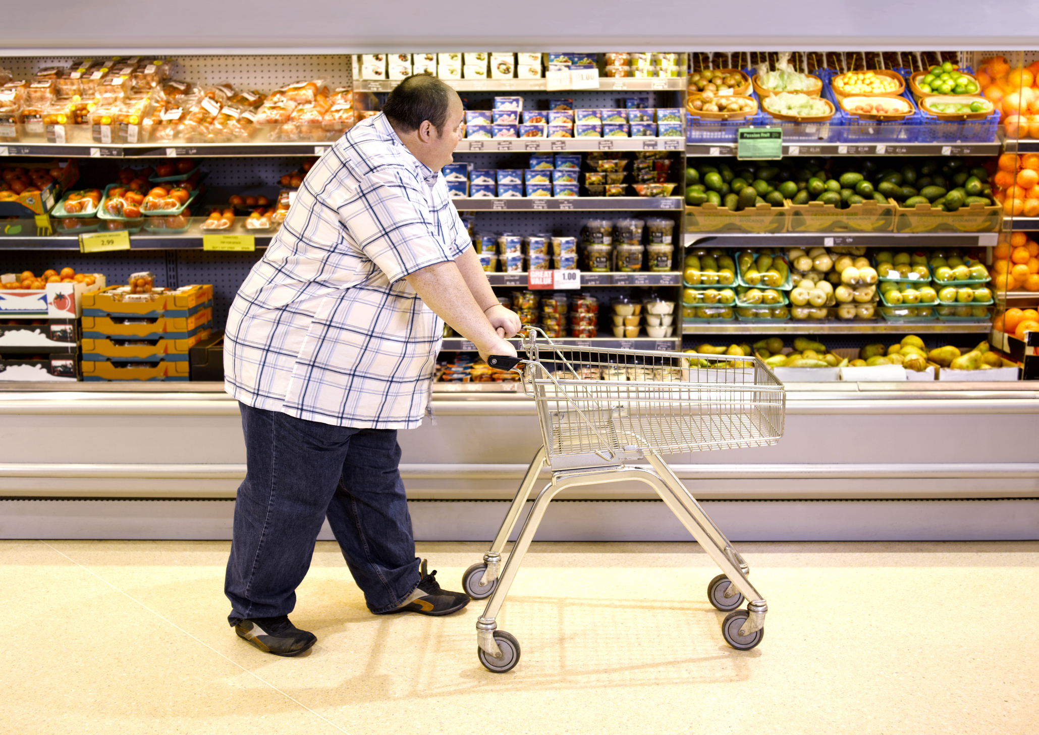 Overweight man passing by healthy food