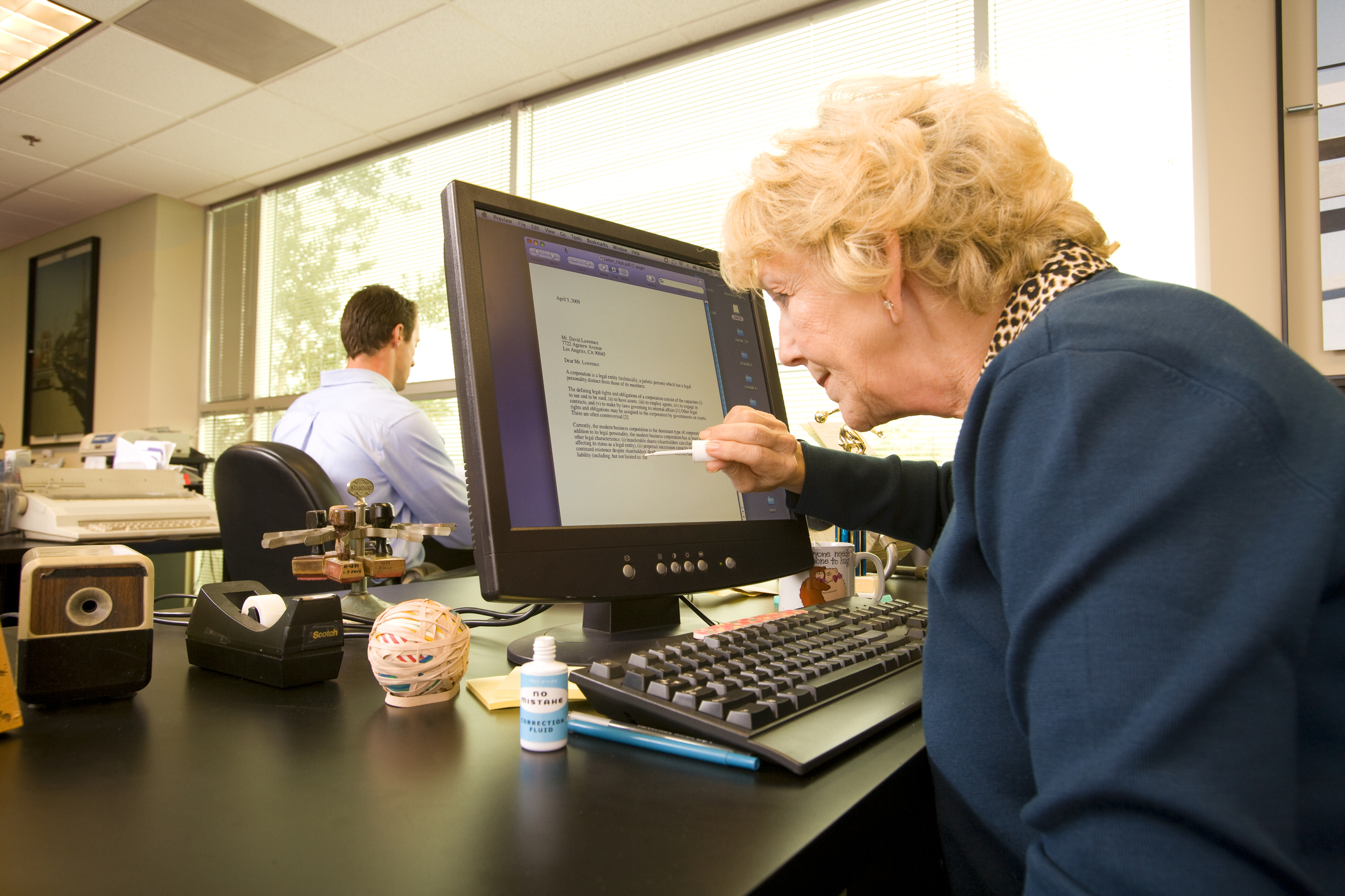 Woman using liquid correction fluid on computer