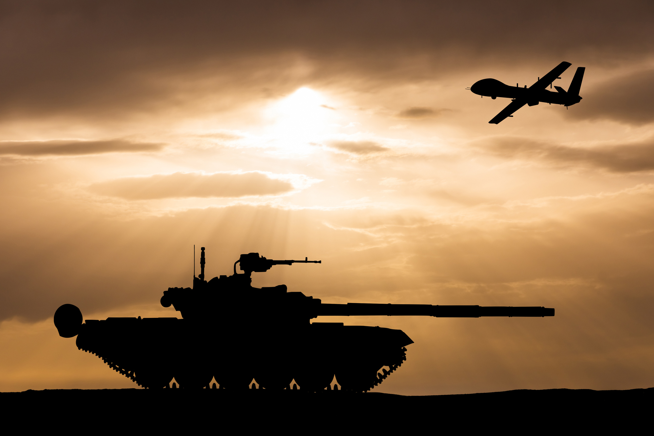 Armored tank and combat drone on the background of the sunset sky