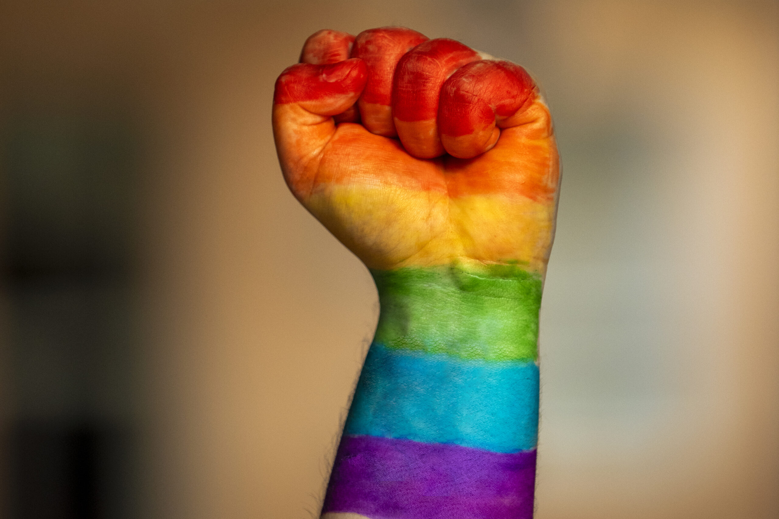 LGBTQ2 Happy Pride Month raised fist with rainbow colors.