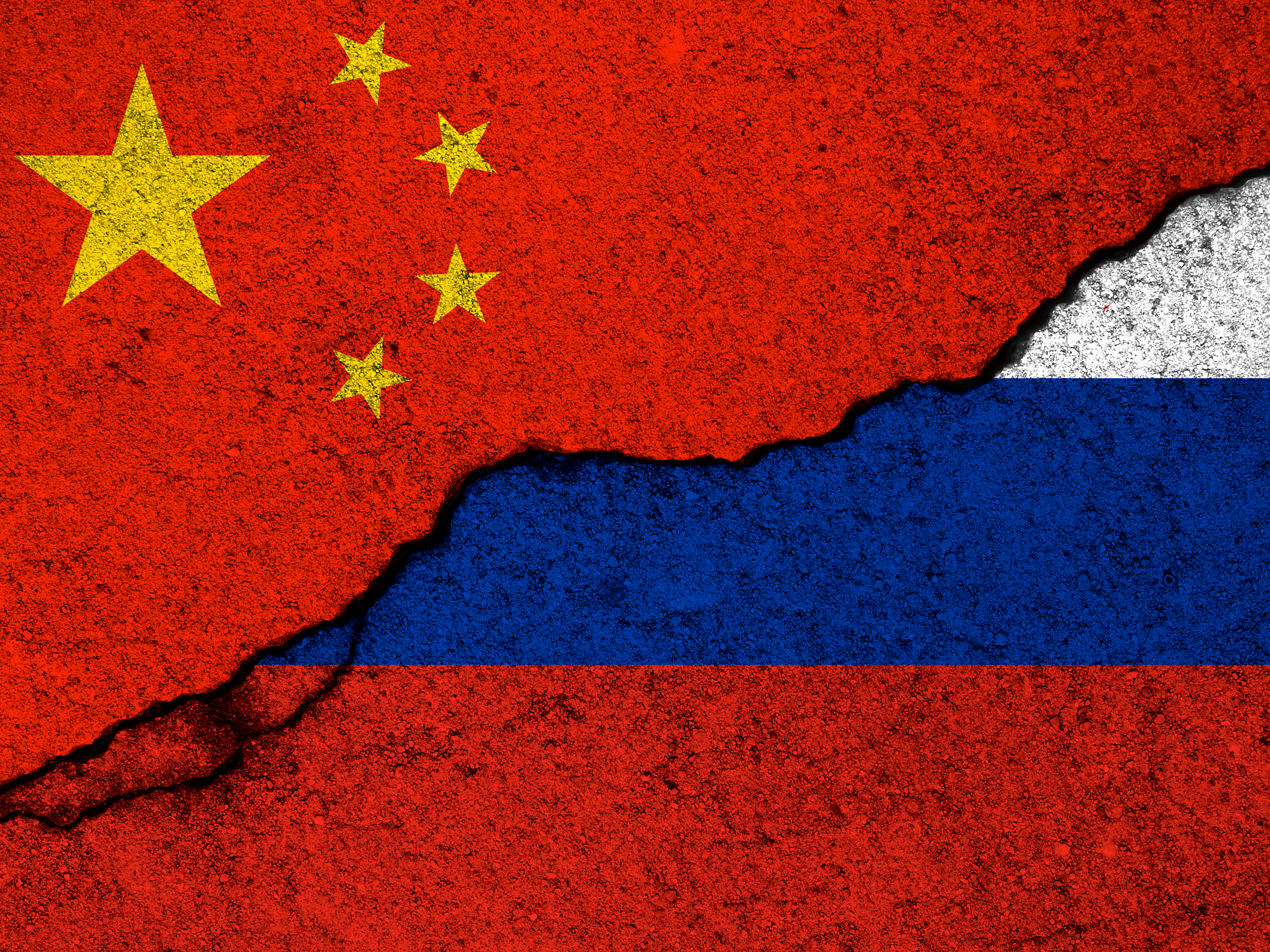 China and Russia relationships background. Country flags painted on cracked concrete walls