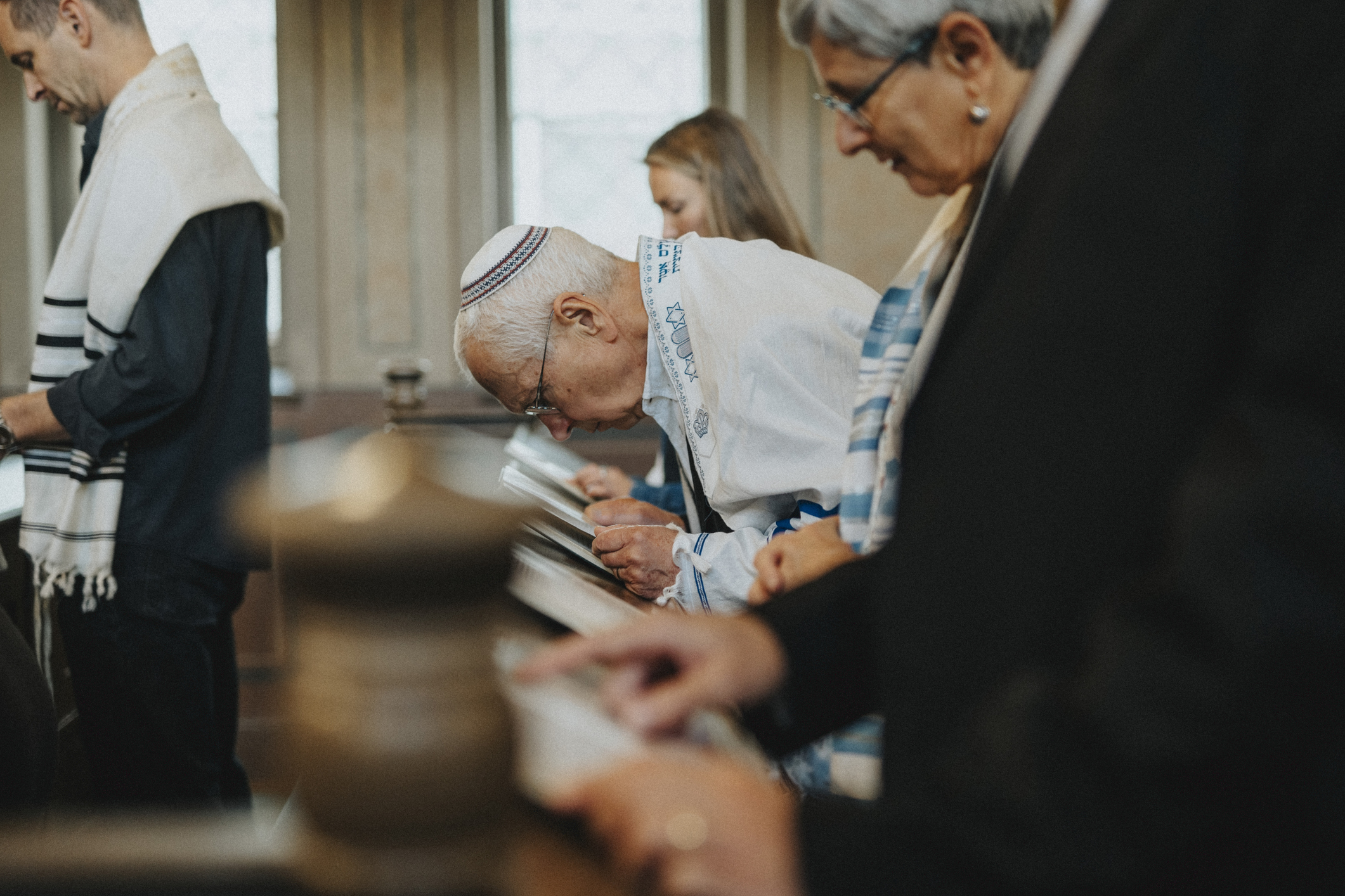 Side view of senior man reciting Amidah during Jewish congregation at synagogue