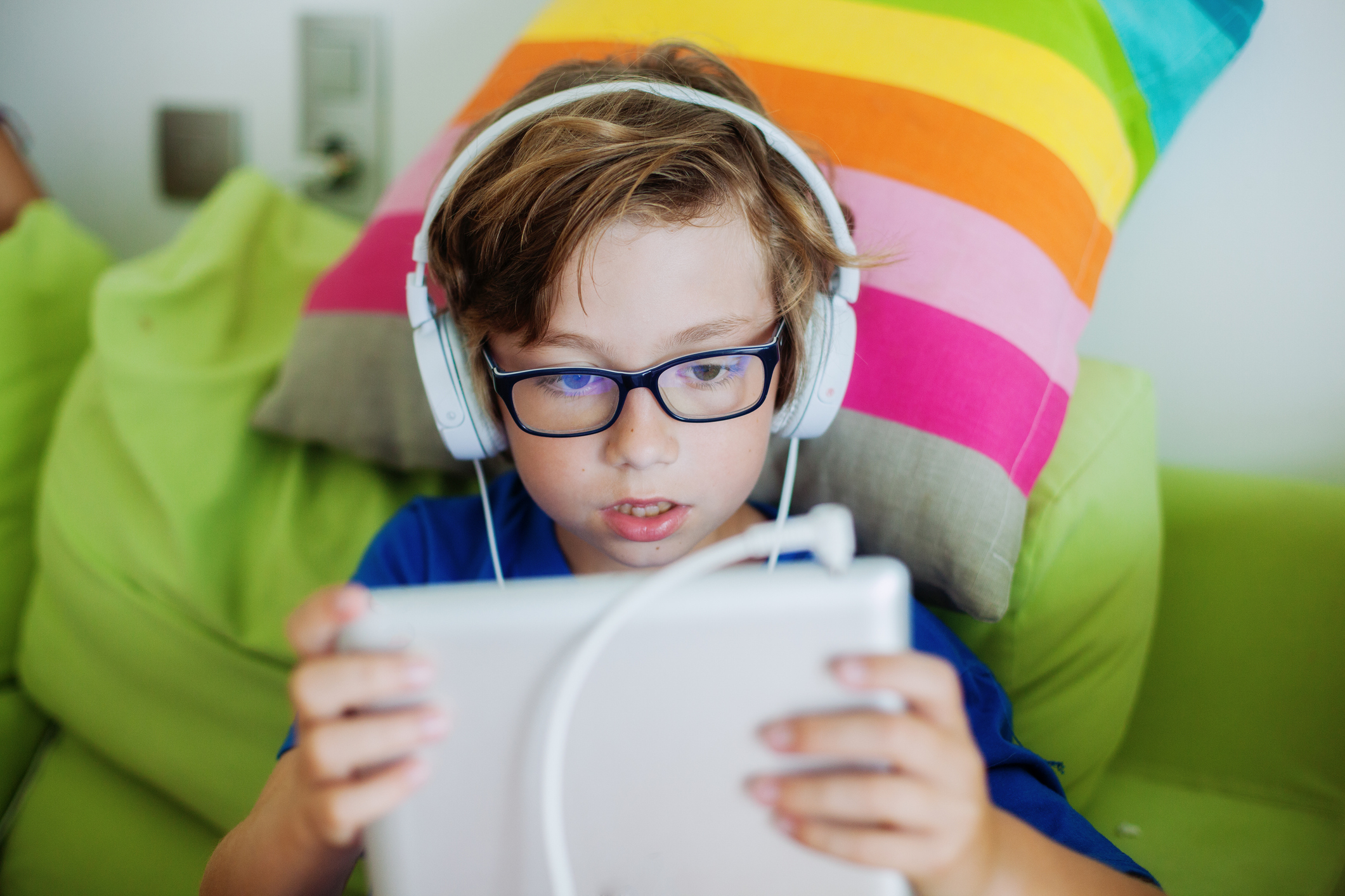 boy using digital tablet with headphones at home