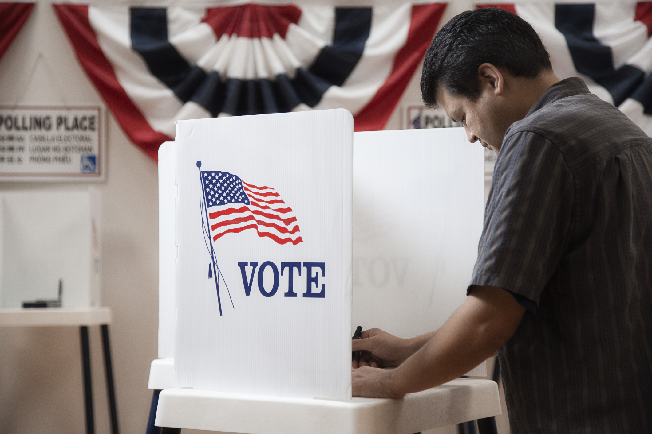 Mixed race voter voting in polling place