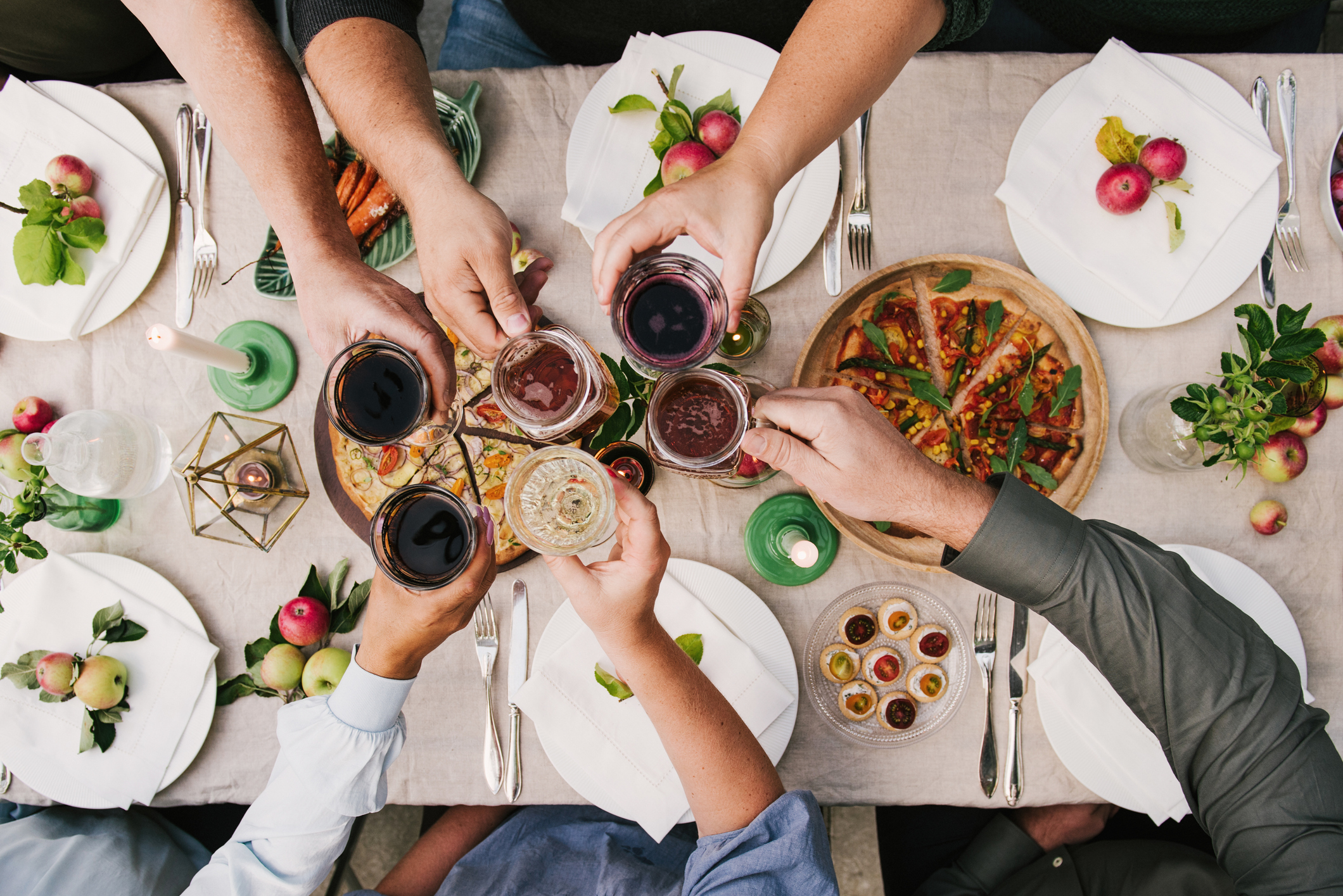 Friends enjoying a dinner together toasting in wine and beer