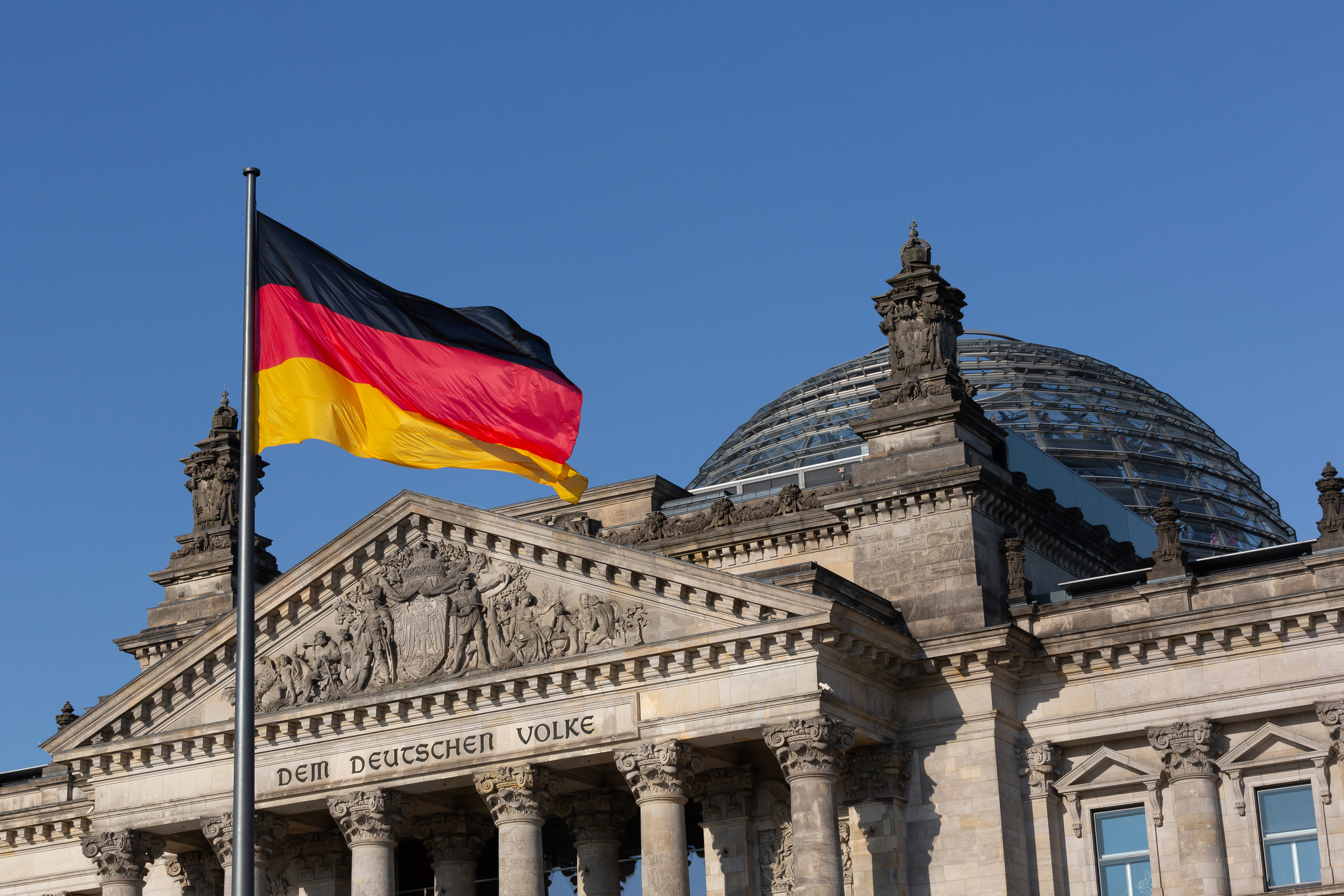 German flag with dome of the Reichstag building (Deutscher Bundestag/ German parliament building)