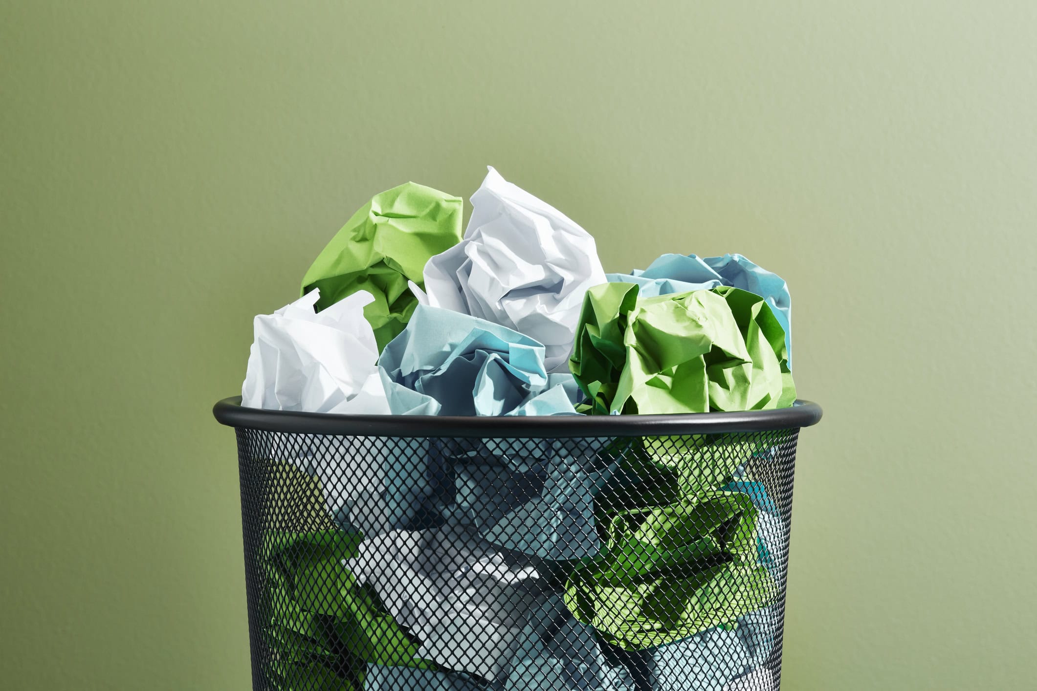 Various coloured crumpled papers in a waste paper basket