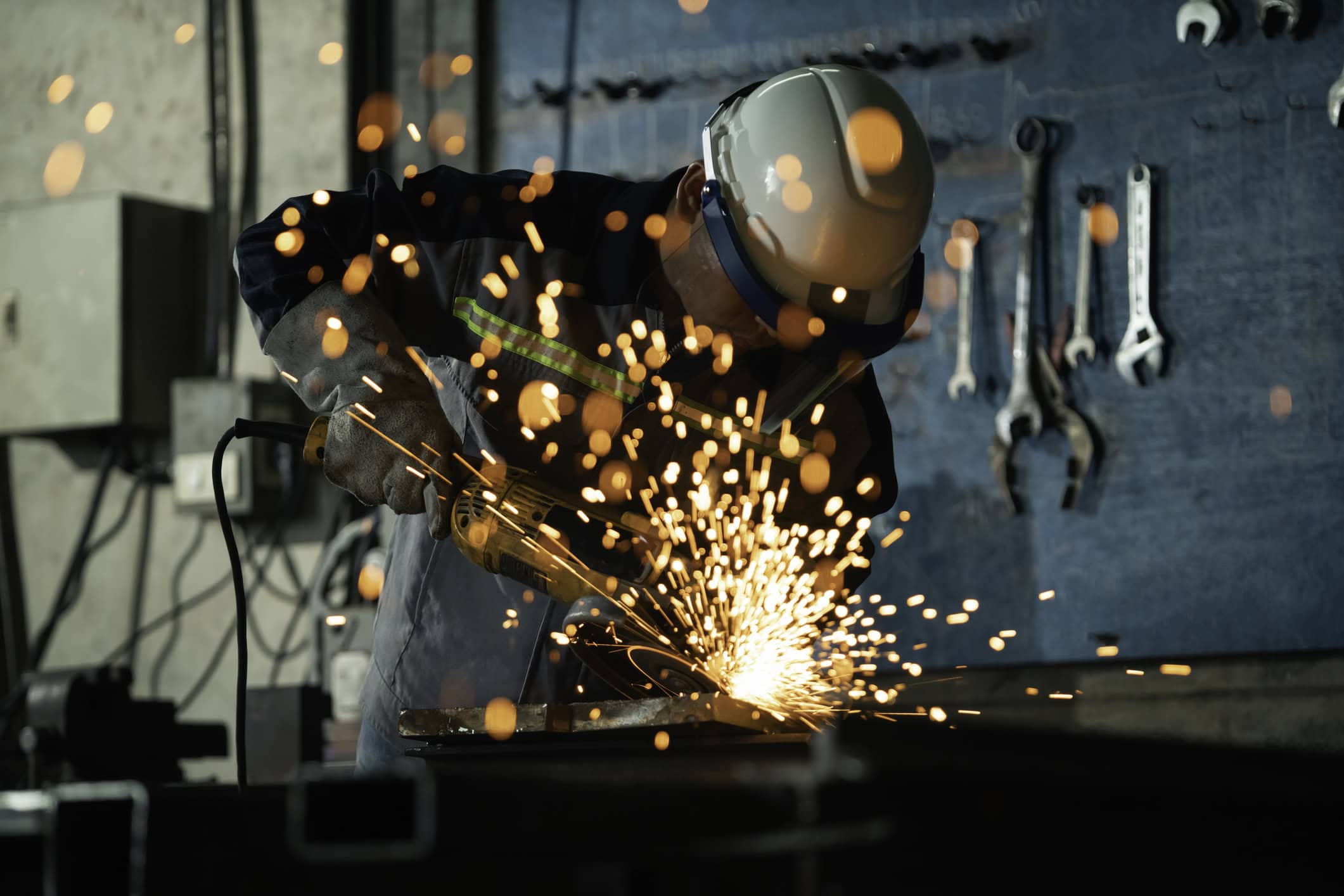 Worker Grinding Steel with Flying Sparks