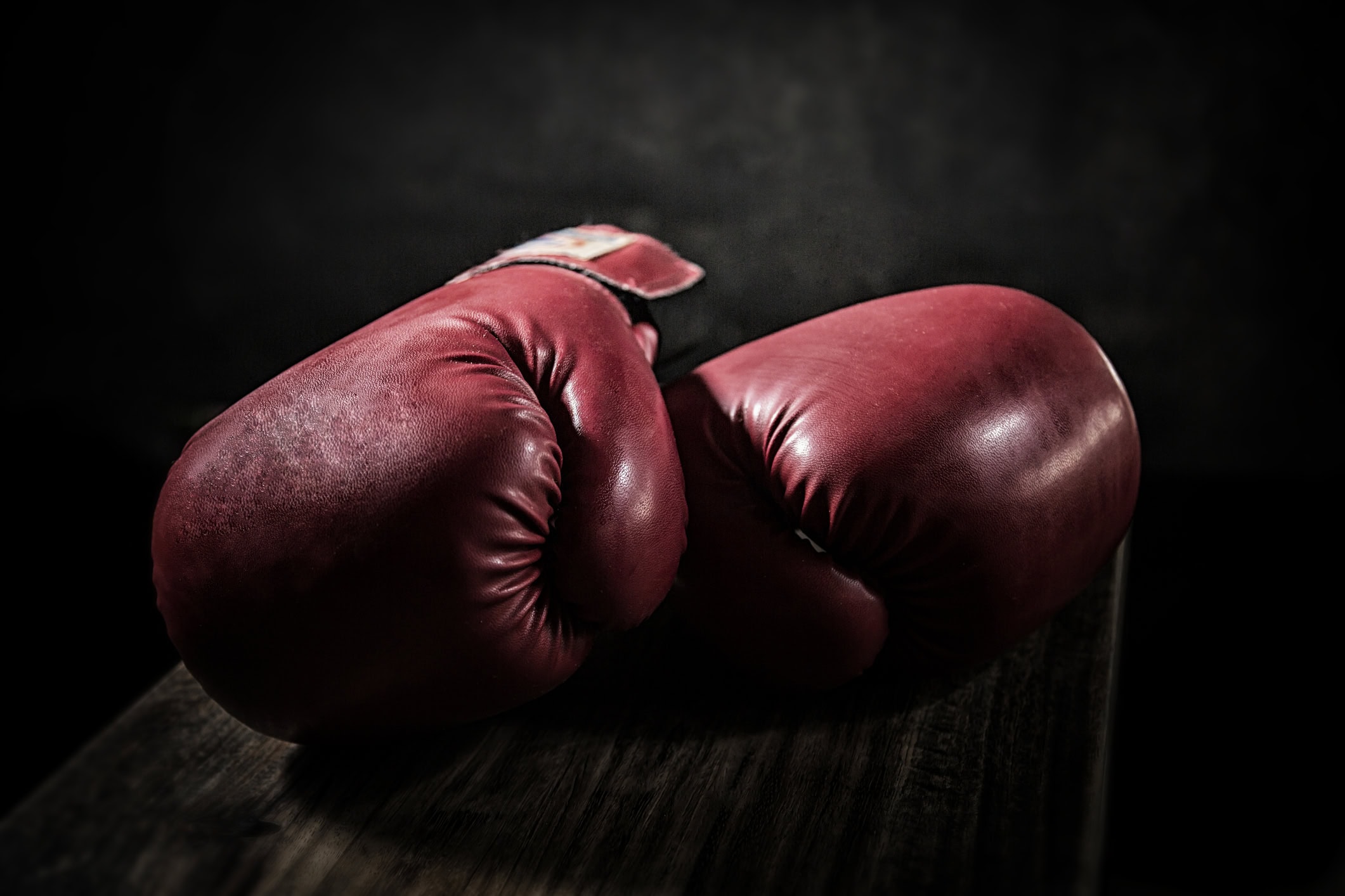 Old boxing gloves lay on the wooden floor. The concept of retirement.