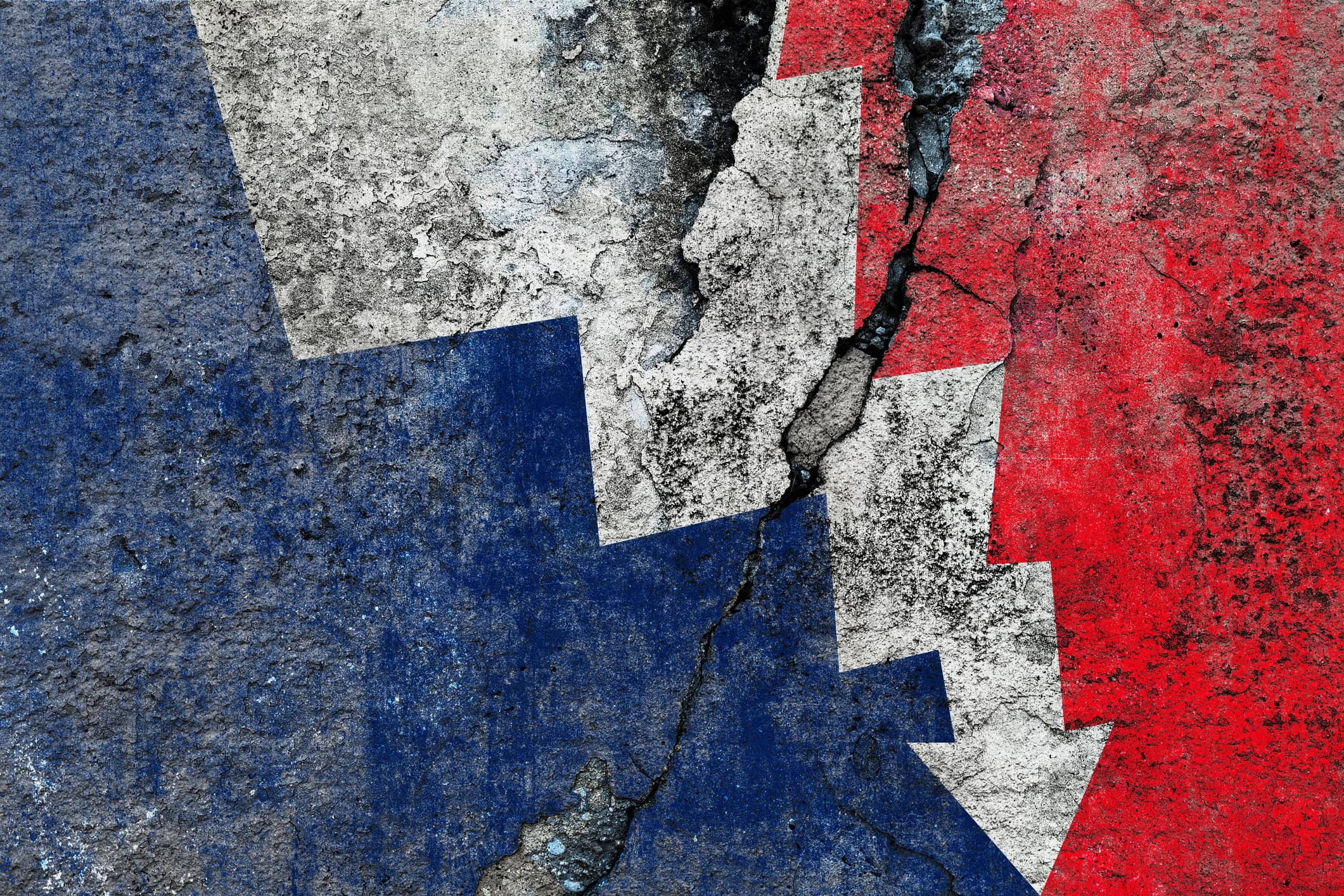 French flag on cracked wall – France economic decline concept with downward arrow
