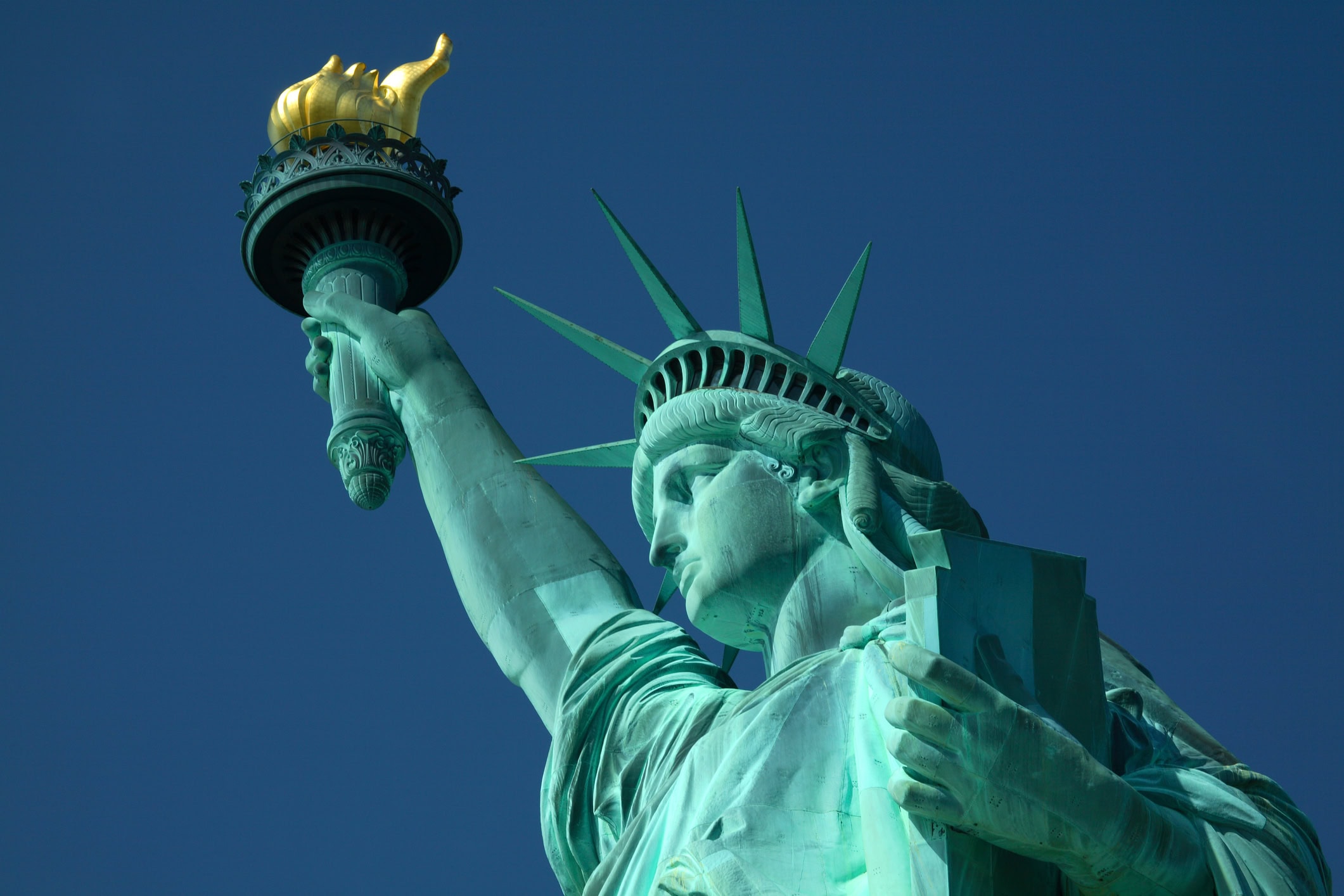 A closeup, upward pointing view of the Statue of Liberty
